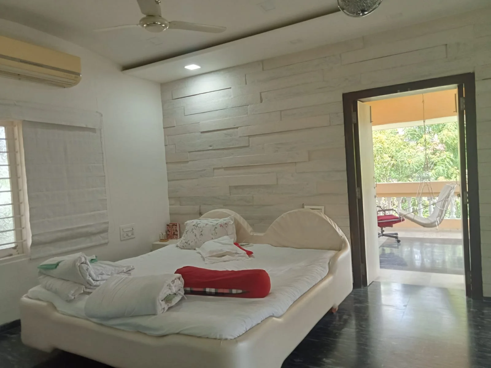 Furnished bedroom opening toward a private balcony
