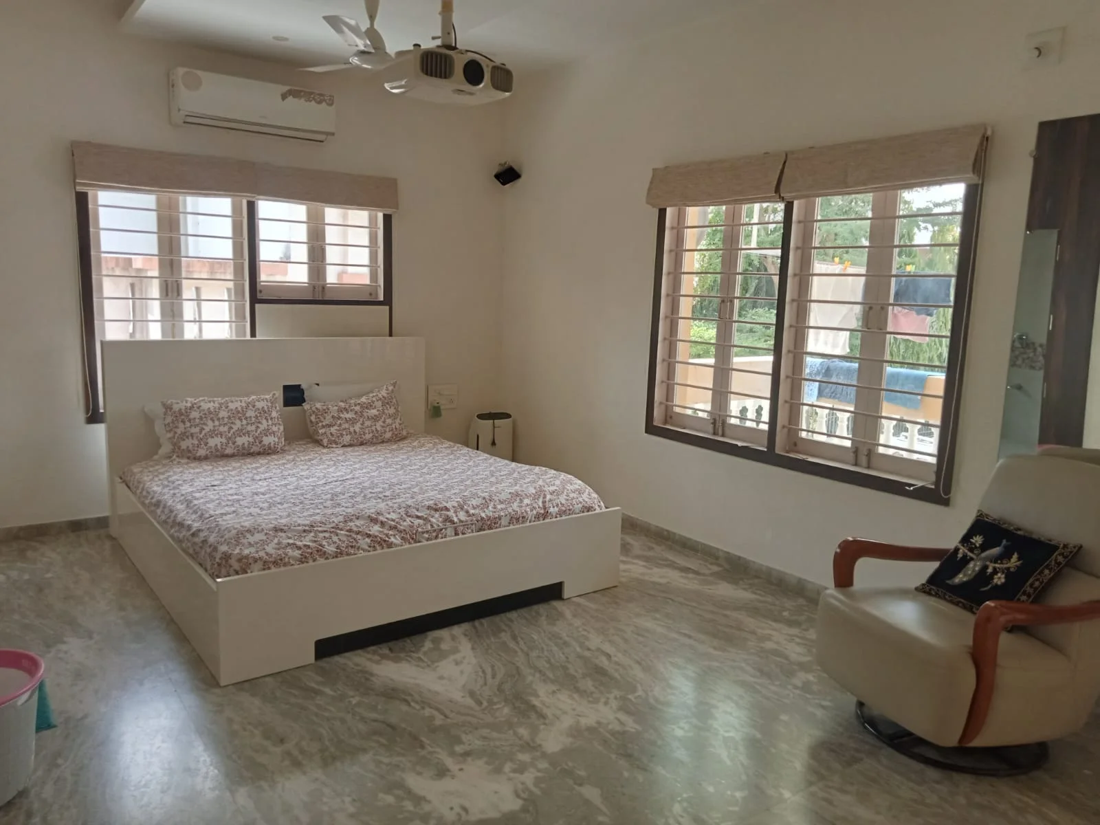 Furnished bedroom with windows and attached balcony